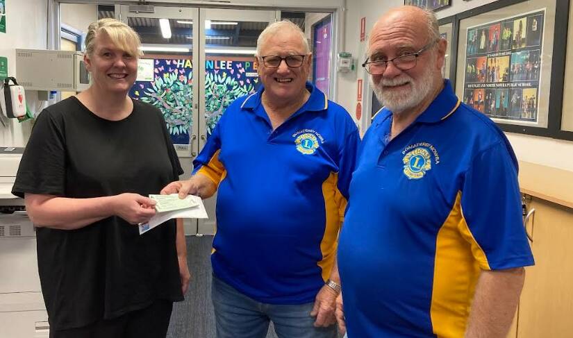 Bomaderry Nowra Lions President Bruce Lamont and Treasurer Bob Mortyn hand Razzamatazz tickets to Hanelnee's assistant principal Nicole Roberts. Picture supplied.