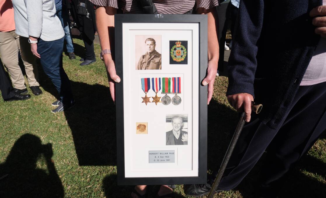 The framed memories of Bill Page, held by his daughter Emily Williams. Picture by Holly McGuinness