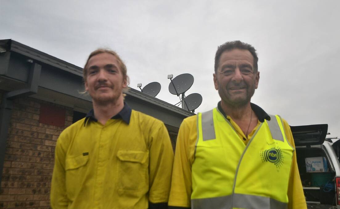 DISHY: Angus Laverack and Sam Bakouris, of nbn, Installing Skymuster satellite internet dishes at the Narooma Leisure Centre, which is an evacuation centre. Picture: CLAUDIA FERGUSON