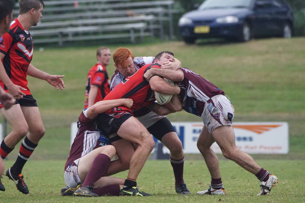 Kiama's Cameron Whittaker is tackled by the Eagles defence. Photo: TIM DELANEY