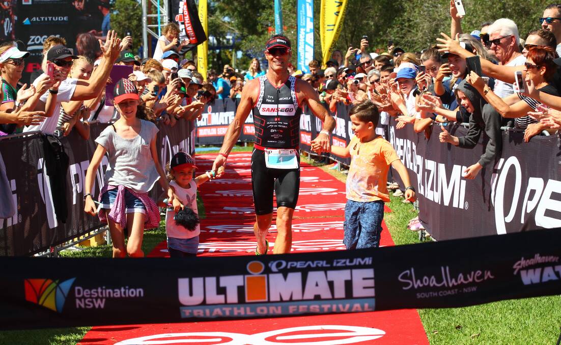 Out injured: Last year's winner Craig 'Crowie' Alexander crosses the line with his three kids Lucy, Lani and Austin. Alexander is out of this year's event. Photo: James Rankin