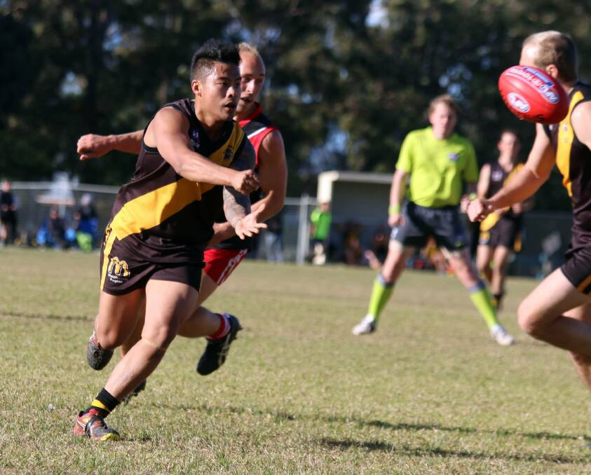 MAN ON A MISSION: Bomaderry Tigers' Josh Lapatha gets a handball away during his side's loss to Wollongong Lions. Photo: CATHY RUSSELL
