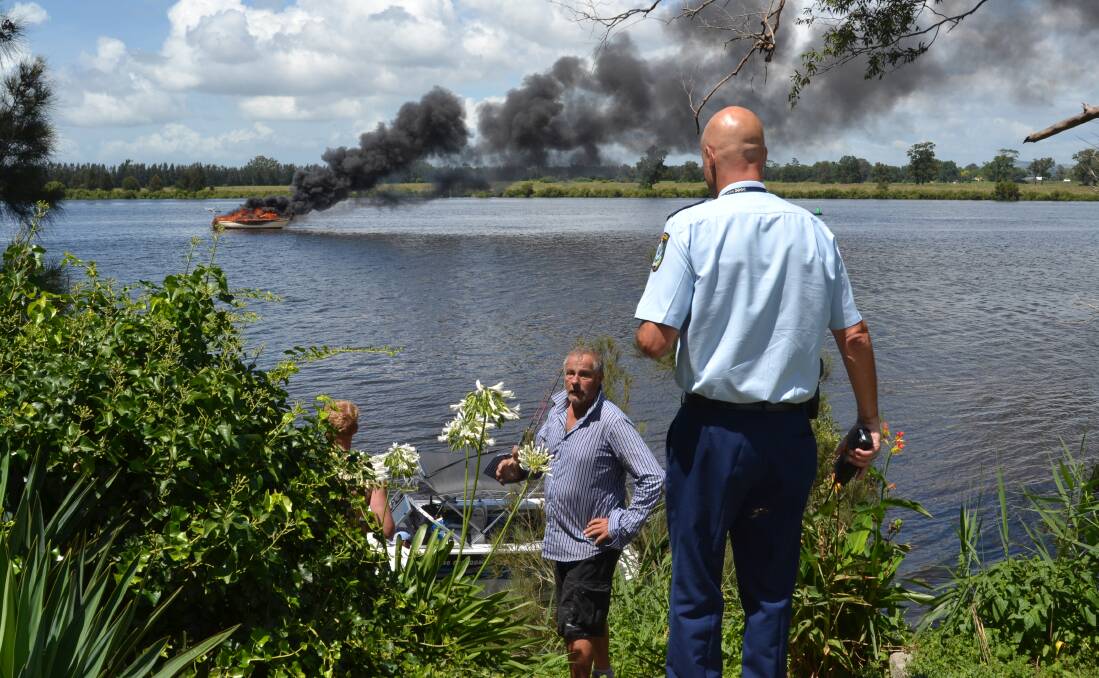 LOSS: David Esdell on the banks of the Shoalhaven River as his yacht burns on January 6. He has since learned it had clipped overhead power lines. 