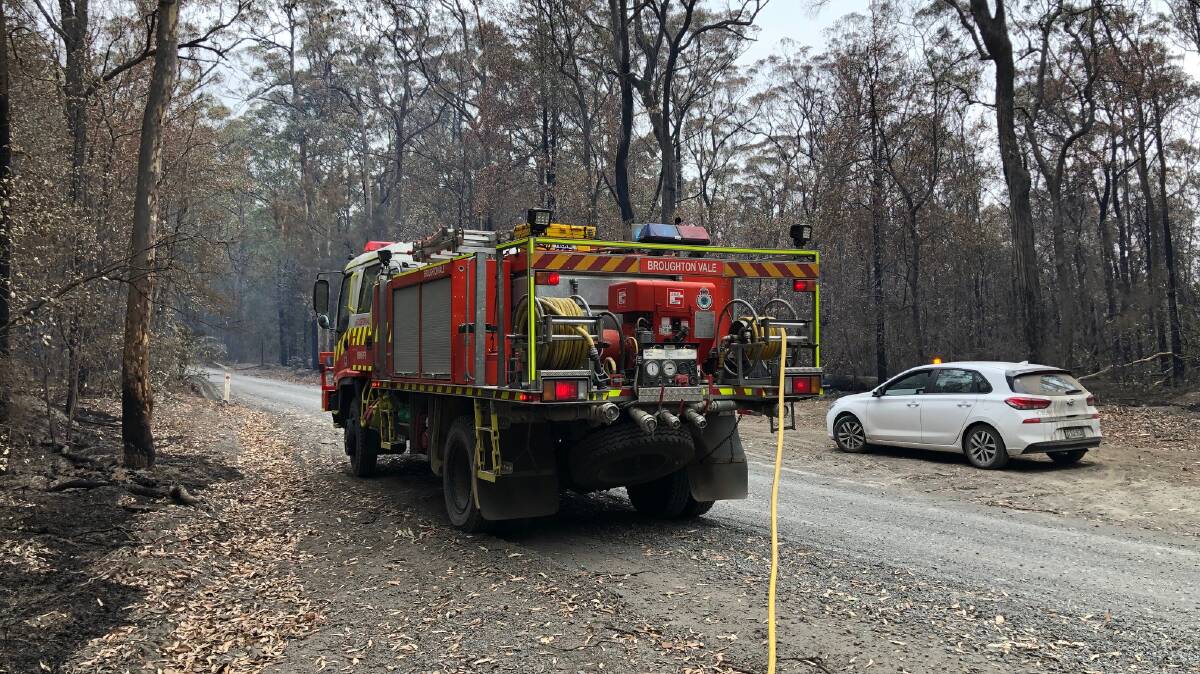 MOPPING UP: The Broughton Vale RFS brigade attends to a flare-up Bugong Road.