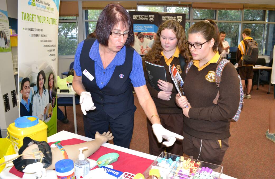 HANDS-ON: Southern.IML Pathology trainer Joyce Sebar demonstrates drawing a blood sample to Shoalhaven High students Emily Hodsdon and Melissa Hatton.