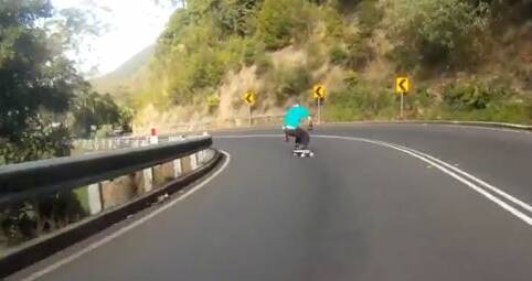 A screen grab from a video showing a skateboarder riding all the way down Bulli Pass. It is one of two videos of people risking their lives down the steep road.