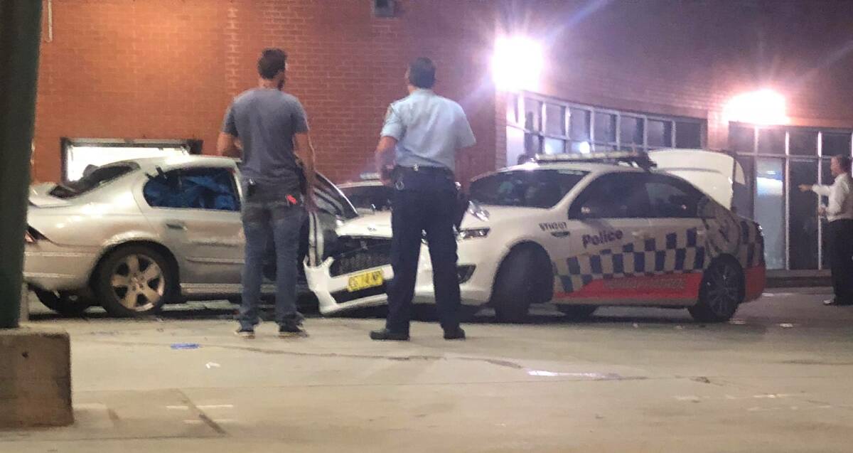 The scene: Officers survey the aftermath of the siege. Pictured is Sean Hollis' Ford Falcon and a damaged police patrol vehicle. Picture: Alexander Bezzina
