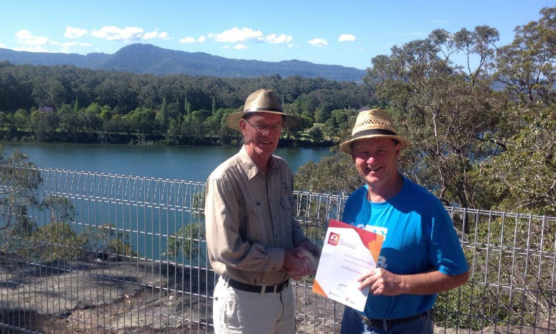 Shoalhaven Landcare chairperson Greg Thompson presents Shoalhaven Riverwatch president Peter Hanson with the NSW Landcare Fish Habitat Innovation Award in 2017.