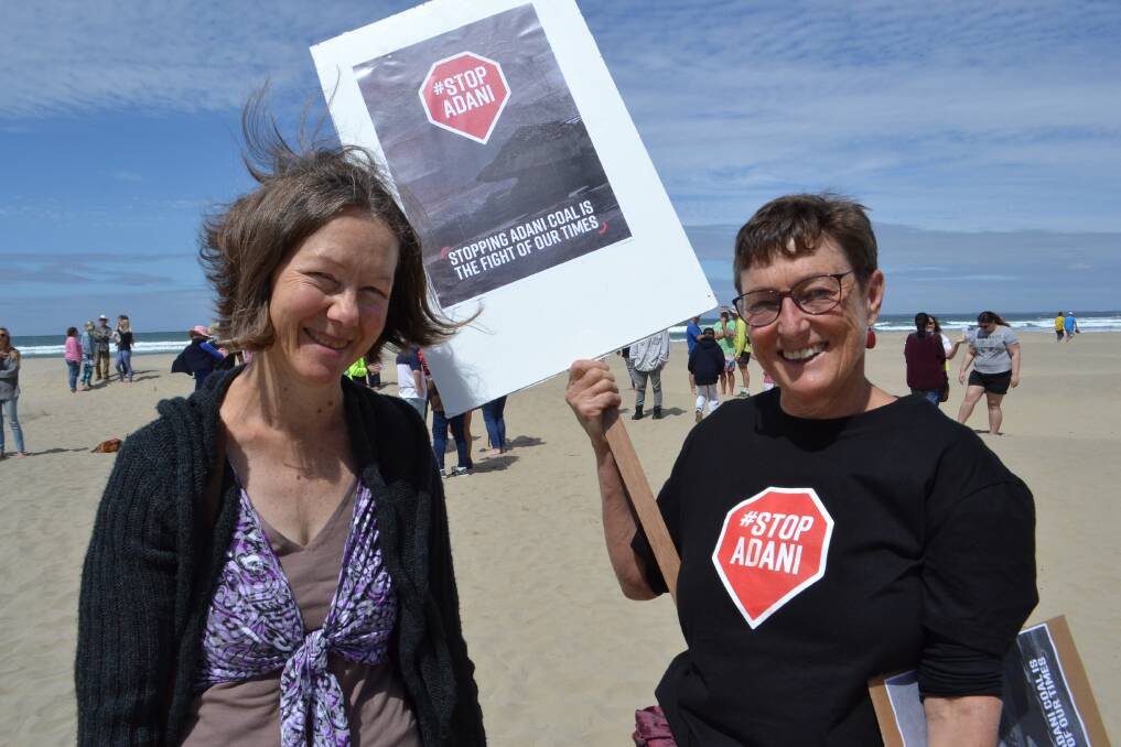 Shoalhaven councillor Kaye Gartner joining the Stop Adani rally to form a human sign for an aerial photo at Seven Mile Beach, in support of converting to renewable sources.