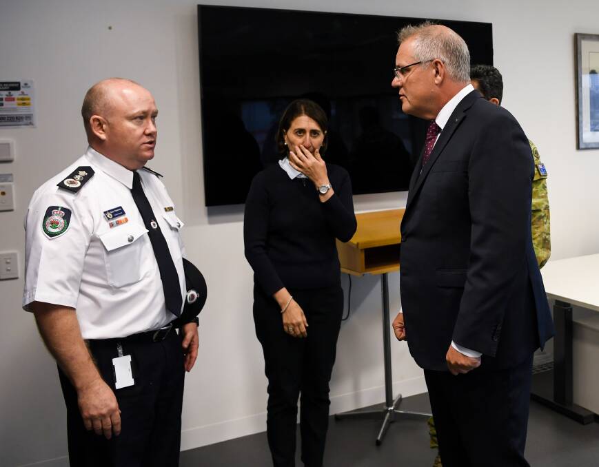 Prime Minister Scott Morrison speaks to RFS Commissioner Shane Fitzsimmons during a visit to HMAS Albatross in Nowra on Sunday. Picture: AAP 
