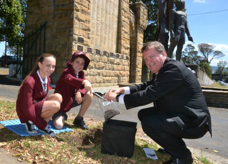 Nowra Public School vice-captain Dylan Johnstone and Carly Davis collect the samples at Nowra with former surveyor general Paul Harcombe, who undertook the local collections for Veterans Affairs.