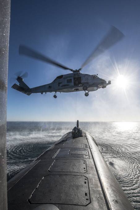 HMAS Ballarat's  MH-60R Seahawk helicopter conducts forward passenger transfer with HMAS Rankin inside Cockburn Sound, Western Australia. Photo: Grahame Kelaher
