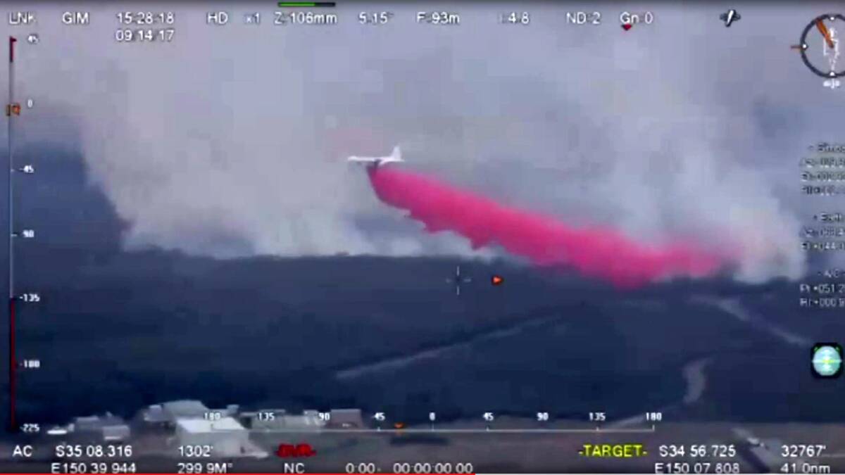 The Rural Fire Service large air tanker Thor drops a load of retardant over the Wreck Bay fire.
