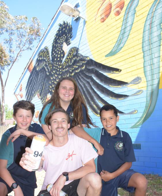 Kiama artist Sam Hall with Nowra East Public students Raymond, captain Savanna O'Brien and Dylan Stewart and the mural.