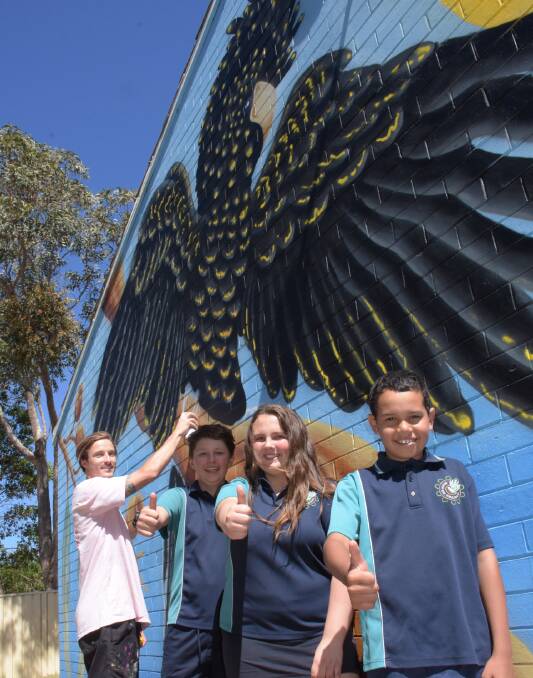 EYE-CATCHING: Kiama artist Sam Hall with Nowra East Public students Raymond, captain Savanna O'Brien and Dylan Stewart with his superb black cockatoo, gum leaves and gum nuts mural 