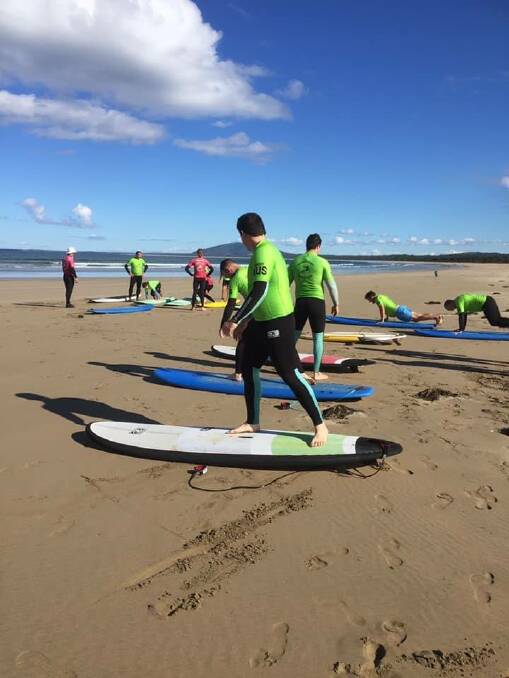 WAVE TIME: Veterans taking part in a try surfing day event at Gerroa with Gerringong Surf School owner, Rusty Moran. 