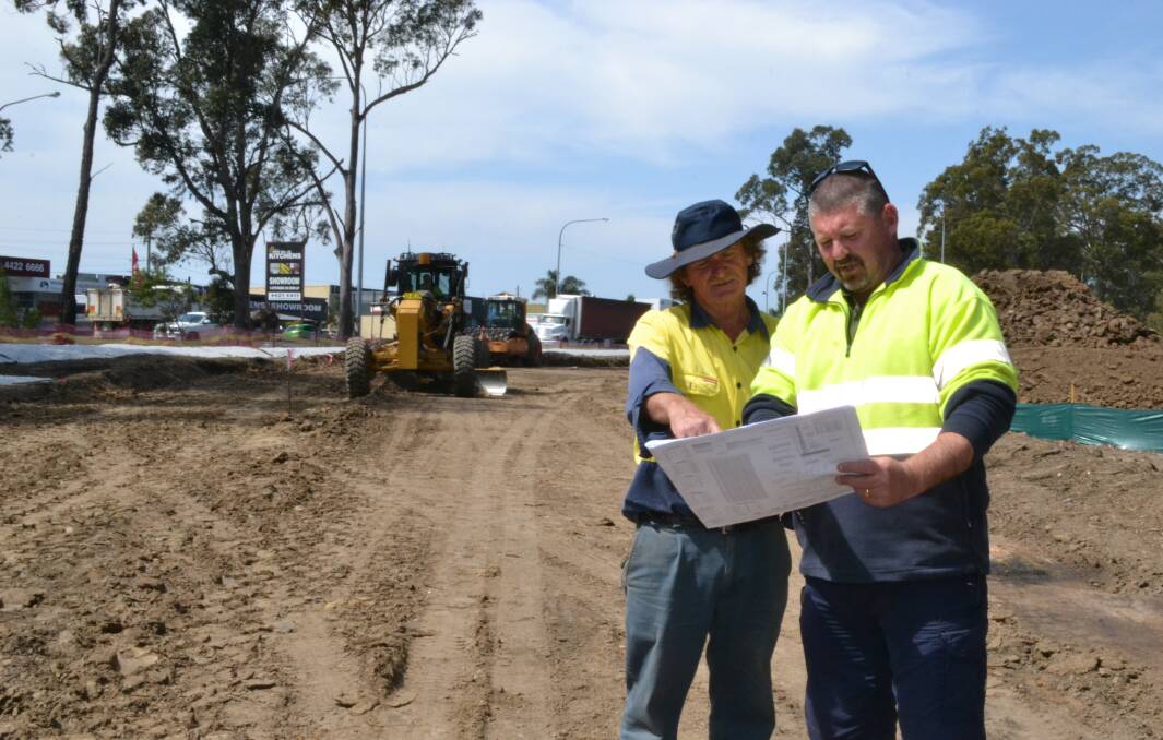 ON A ROLL: Shoalhaven City Council leading hand David Evelyn (left) and supervisor Darren Tynan look over the plans for the Browns and Flinders roads link at South Nowra as roller driver Dean Elliott and grader driver Steve Povall continue the work.