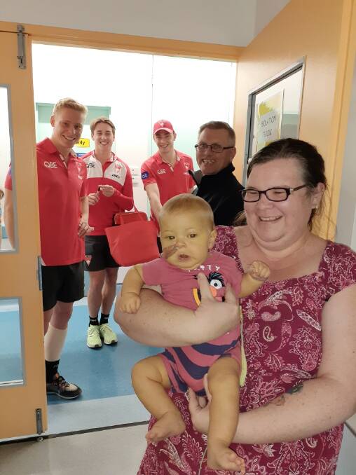 VISIT: Brad Clark and Peta Browne with Isaac and Sydney Swans players who were visiting the liver ward in Westmead in July (from left) Isaac Heeney, Will Hayward and Mathew Ling. Issac was named after the Swans star Heeney. Photo: Supplied