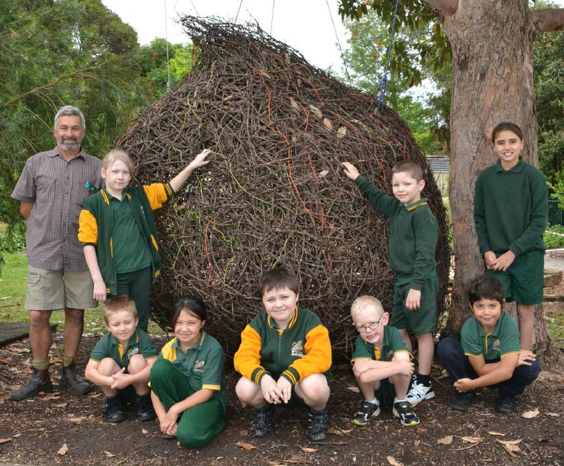STUNNING: Nowra East Public School’s Community Garden co-ordinator with students (back) Shelby Herbert, Liam Flaherty, Bryah Longbottom, (front) Oliver Berg, Cheyanne Longbottom, Nicholas Harkness, Brody Mallitt and Caleb Thomas with the Sculpture By The Sea exhibit Passage Of Time.
