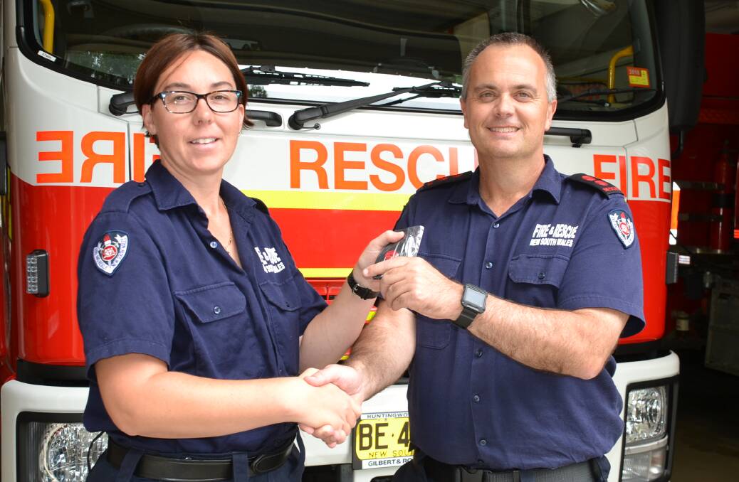Fire and Rescue NSW Nowra captain John Dun presents Rebecca Chapman with her acting deputy captain epaulettes.