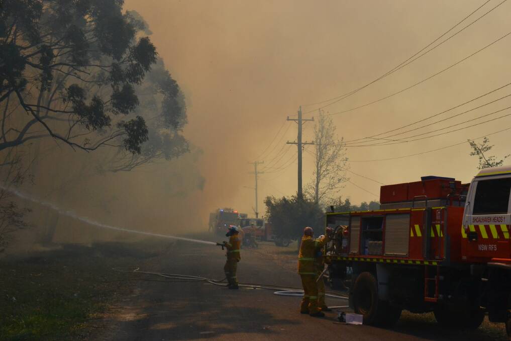 Rural Fire Service crews prepare to face the fire front as it approaches Filter Road in West Nowra.
