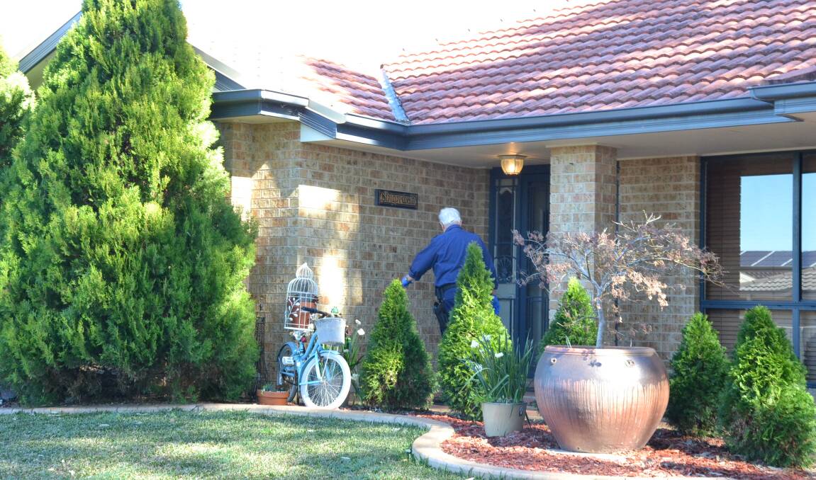 INVESTIGATION: A NSW Police forensic officer enters the home in Bluewattle Road, Worrigee which was the scene of a home invasion in the early hours of Wednesday.
