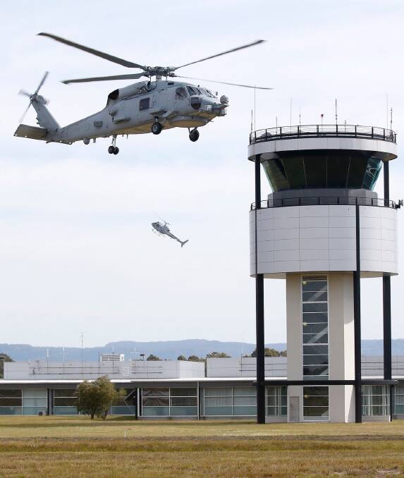 GREAT SHOT: Former HMAS Albatross photographer Kel Hockey’s photo of one of the RAN’s new Romeo Seahawks hovering next to the air traffic control tower at Albatross, with a Squirrel helicopter in the background going almost vertical which won the Rosemary Rodwell Memorial Prize.