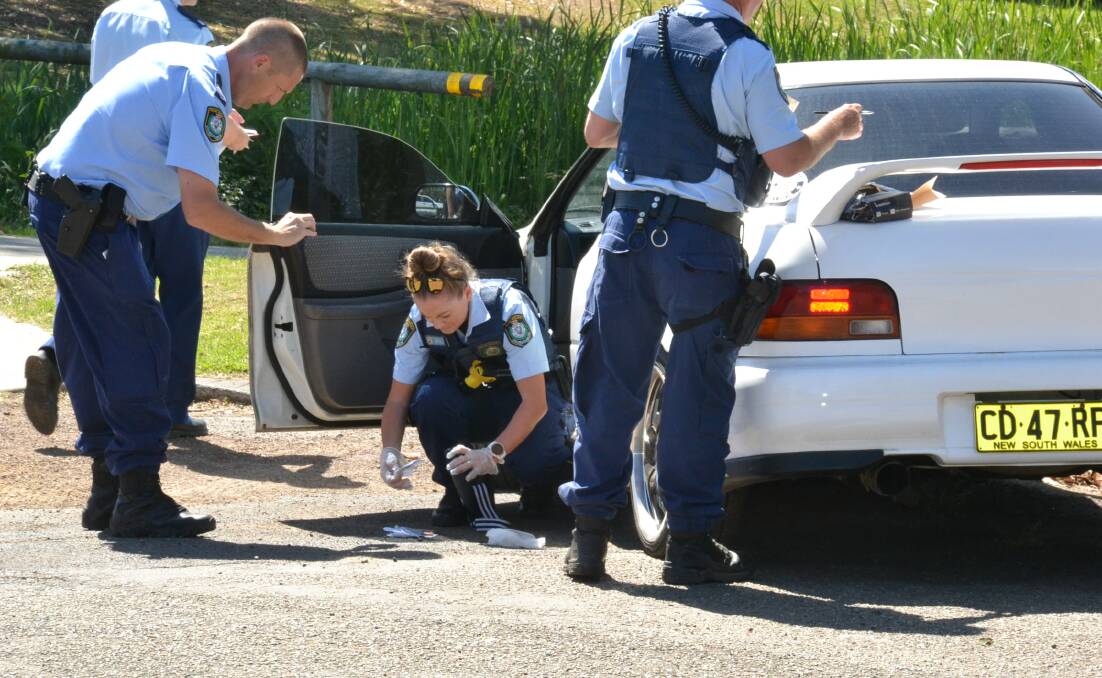 SEARCH: Nowra police comb through the vehicle for evidence following Tuesday afternoon's dramatic pursuit.