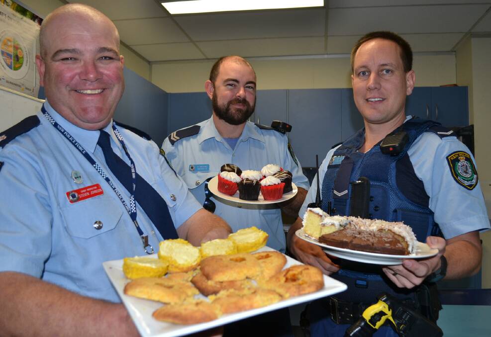 SCRUMPTIOUS DELIGHTS: Shoalhaven LAC Chief Inspector Steve Johnson, Senior Constable Brian Balding and Constable Simon French with some of the delights from Thursday’s morning tea.