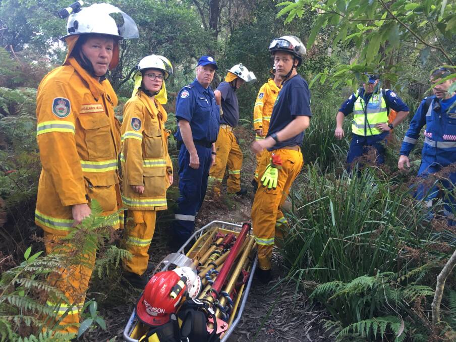 Rural Fire Service crews prepare the Stokers Litter to carry the injured man.