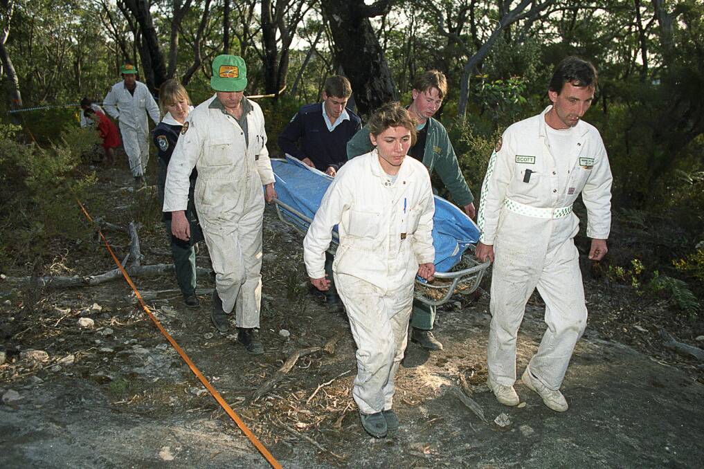 Rescue workers remove the body of a female British backpacker after it was discovered in the Belanglo State forest. Police would go on to find others, leading to the capture and conviction of serial Killer Ivan Milat. Picture: Les Smith 