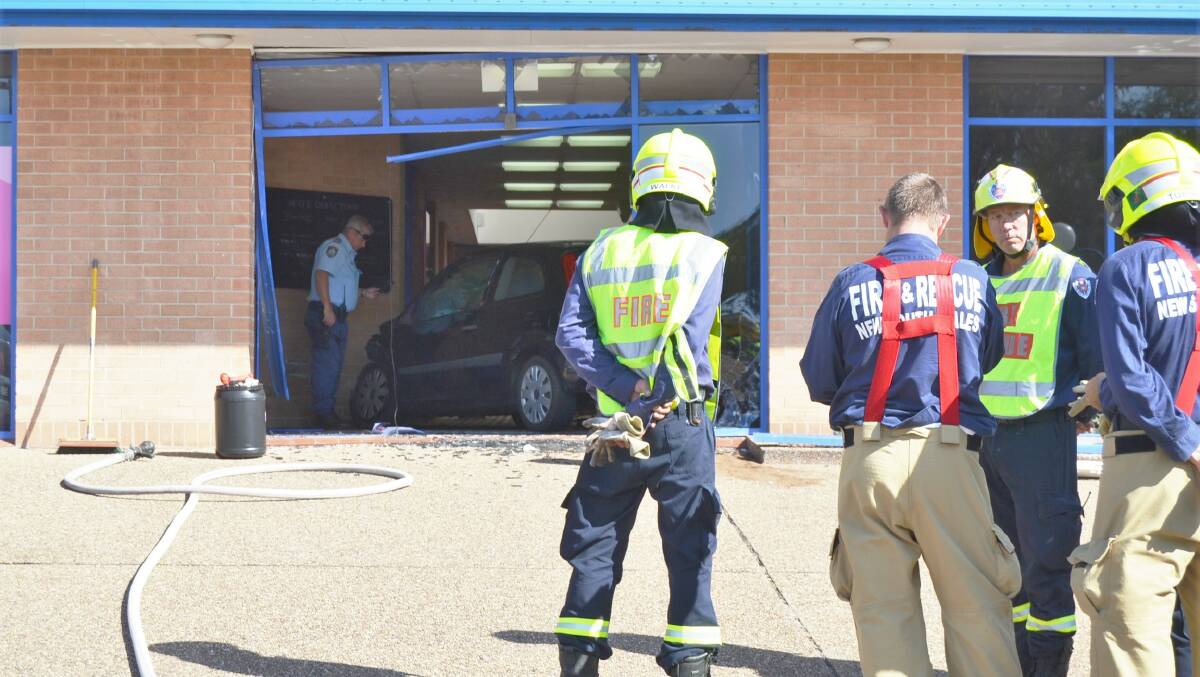 A car is being assessed by emergency service workers as it sits in the Medical and Professional Centre building in Boree St, Ulladulla. Picture: Sam Strong. 