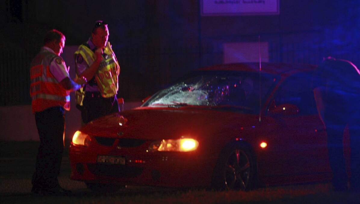 Police and paramedics examine the Holden Commodore damaged in Friday night's collision. Picture: Georgia Matts