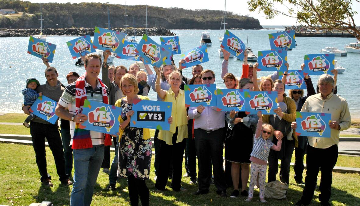 STANDING PROUD: Roger Nee and Emily Jenkins stand in front of a group of 50 Milton-Ulladulla businesses who have united to publicly support the “yes” vote in the marriage equality postal survey. Photo: Jessica McInerney.