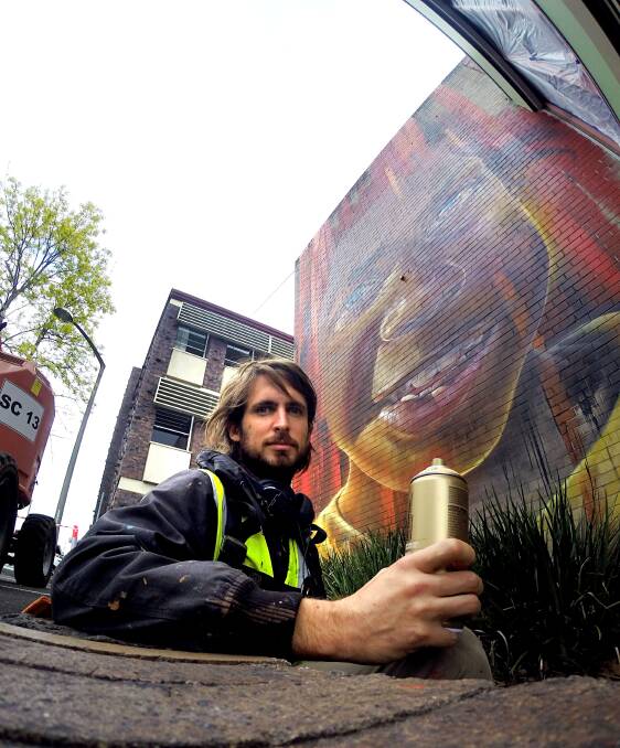 PROUD: Matt Adnate with his mural on Nowra Library's back Picture by: Jessica Long