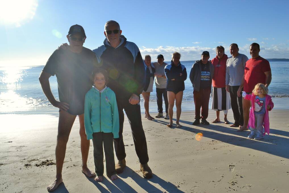 WINTER FUN: Oldest members John Stapleton, 72, and Geoff Mapledoram, 71, with youngest member Juliette Levy, 7, and some of the other brave Wobbegongs take a moment to warm up after their morning swim on Friday. 