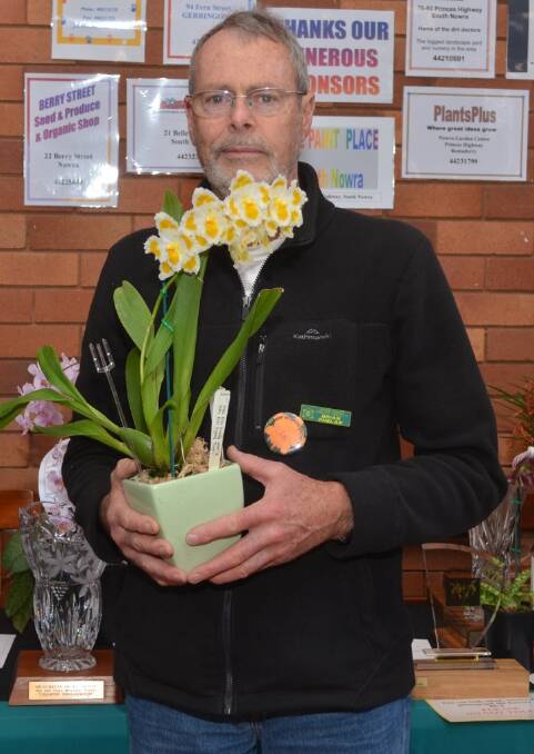PASSION: Shoalhaven Orchid Society member Brian Phelan with his Champion Oncidiinae Orchid. Photo: supplied. 
