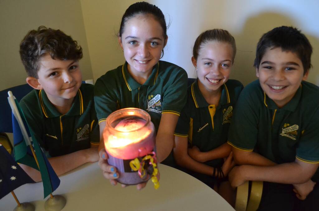 RESPECT: Nowra East Public School leaders Chris Aivaliotis, Aysha Stewart, Skylar Tonkin and Ben McLeod light a candle to honour those who came through the Stolen Generations. 