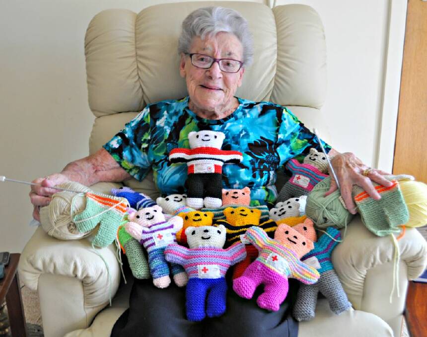 KNITTING WITH LOVE: Moira Power has knitted close to 1800 Trauma Teddies in four years. She was presented with a certificate of appreciation by the Sussex Inlet Branch Australian Red Cross when she knitted her 1000th teddy (pictured centre, red and black) 