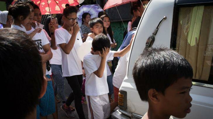 Children and relatives mourn while walking behind a hearse during a funeral held for Alex Hongco killed in a police drugs raid in December. Photo: Dondi Tawatao/Getty Images