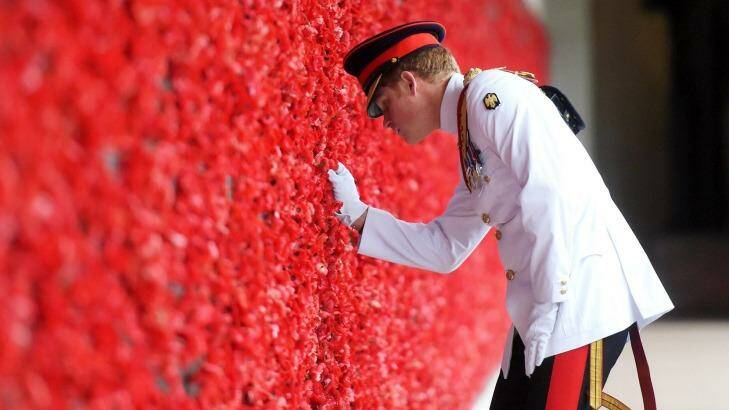 Prince Harry places a poppy at the Roll of Honour during a visit to the Australian War Memorial on Monday.  Photo: Pool/Getty Images