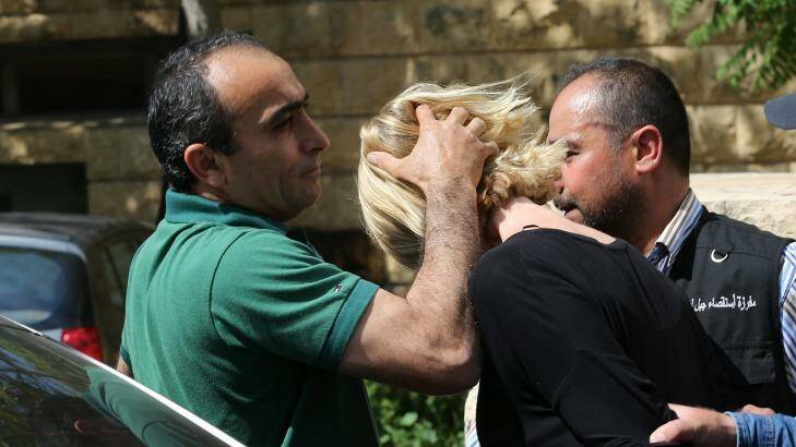 A Lebanese plainclothes policeman prevents Ms Brown from looking towards journalists as she was taken from the courthouse. Photo: Hussein Malla