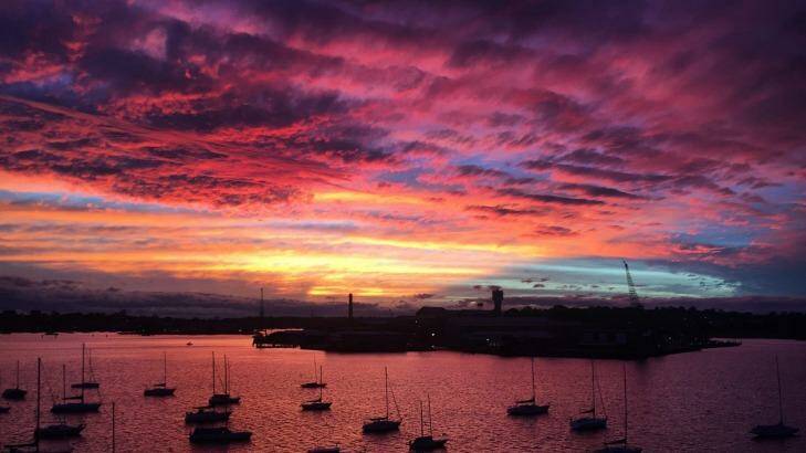 A blue, gold, pink and purple sunset looking over Cockatoo Island, Sydney. Photo: Daniel Adams