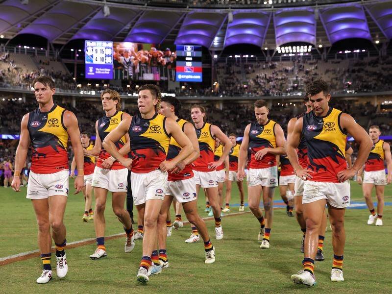 A dejected Adelaide Crows team leave the Optus Stadium field after a third loss in three. (Richard Wainwright/AAP PHOTOS)