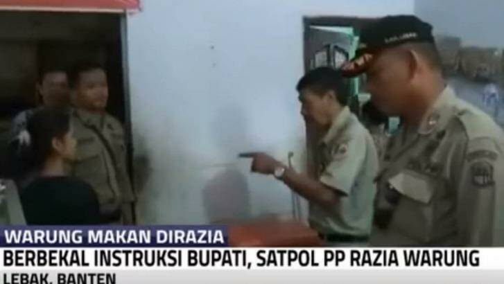Police during the raid to enforce local bylaws which have now generated a public and political backlash. Photo: Kompas TV
