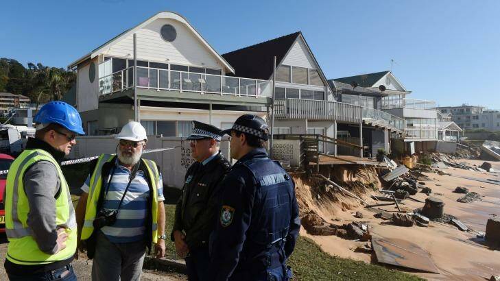 Warringah Council group manager a natural enviroments Todd Dickinson (left) and consultant coastal engineer specialist Angus Gordon (2nd from left) speak with NSW Police during an  inspection of damaged beachfront homes. Photo: DEAN LEWINS