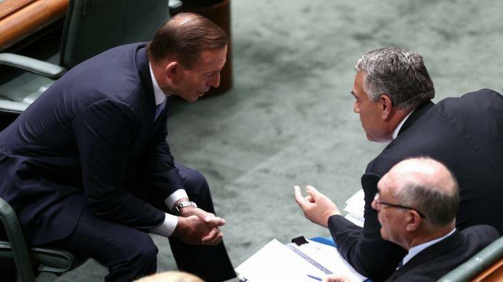 The PM consults with Joe Hockey during Question Time.  Photo: Alex Ellinghausen