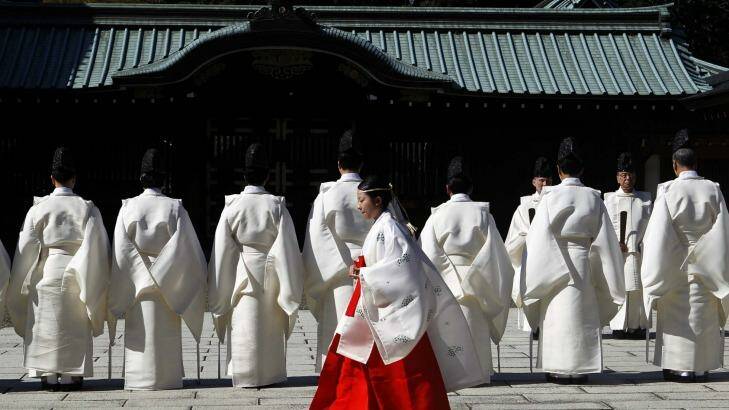 Controversial: A shrine maiden walks behind Shinto priests before a ritual to cleanse themselves at the Yasukuni Shrine during the Annual Autumn Festival in Tokyo on October 17. Photo: Yuya Shino