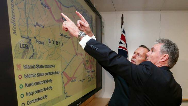 Prime Minister Tony Abbott and the ASIO director-general Duncan Lewis examine the year-old map showing Islamic State's presence in Iraq and Syria. Photo: Alex Ellinghausen