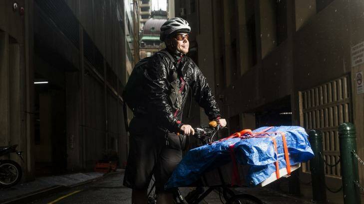 Michael Dodds, from Kranq Couriers in Sydney, works in the rain. Photo: Nic Walker